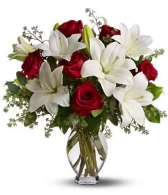 Red roses and white lilies in a clear glass vase