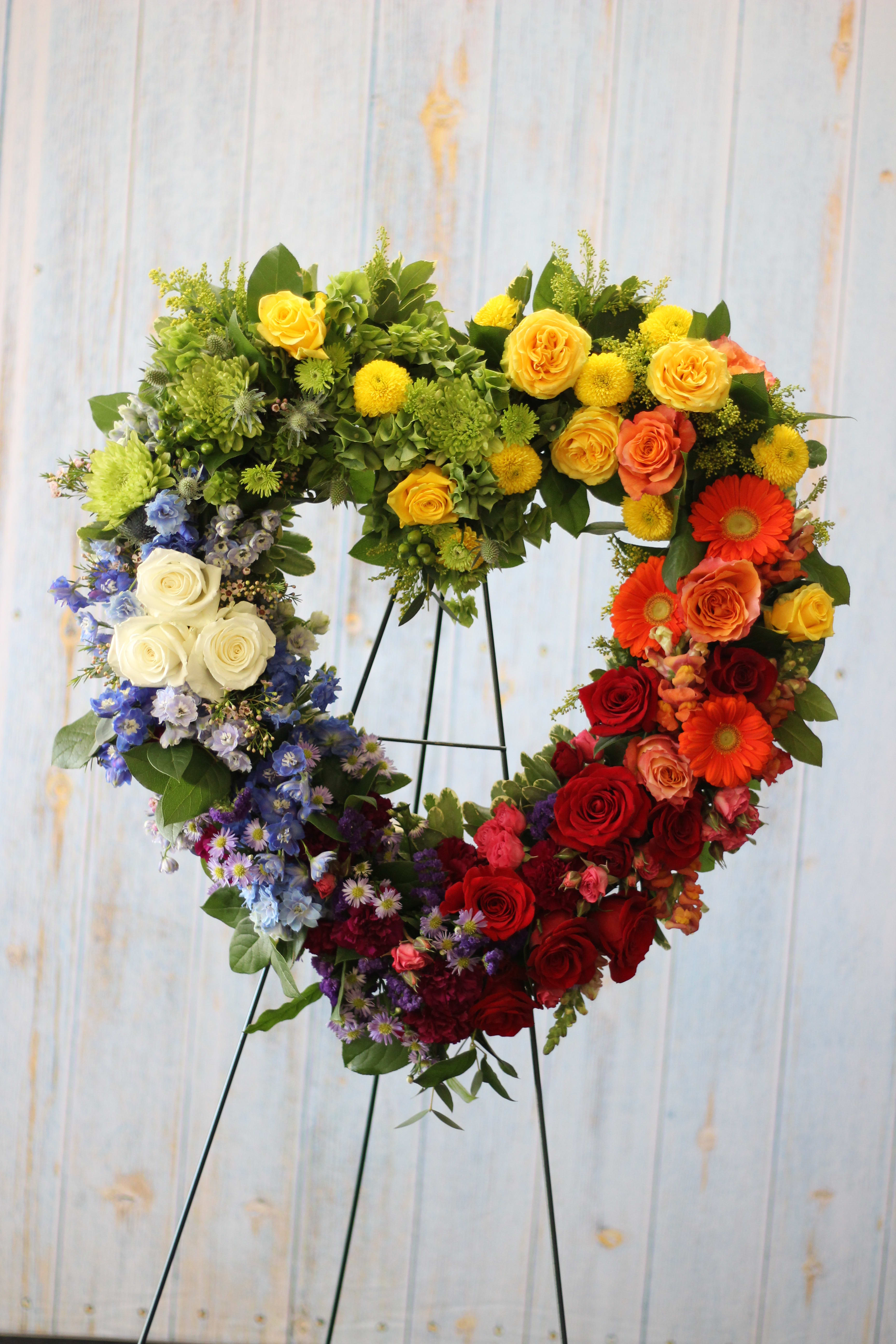 The Lovers, The Dreamers - This stately rainbow display is a memorable tribute feature a variety of premium blooms in all of the vivid colors of the rainbow.   