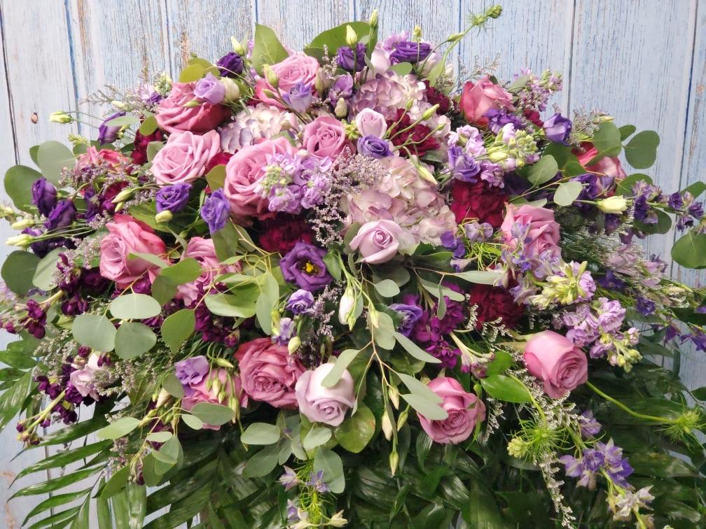 Large bouquet of pink and purple roses with mixed greenery
