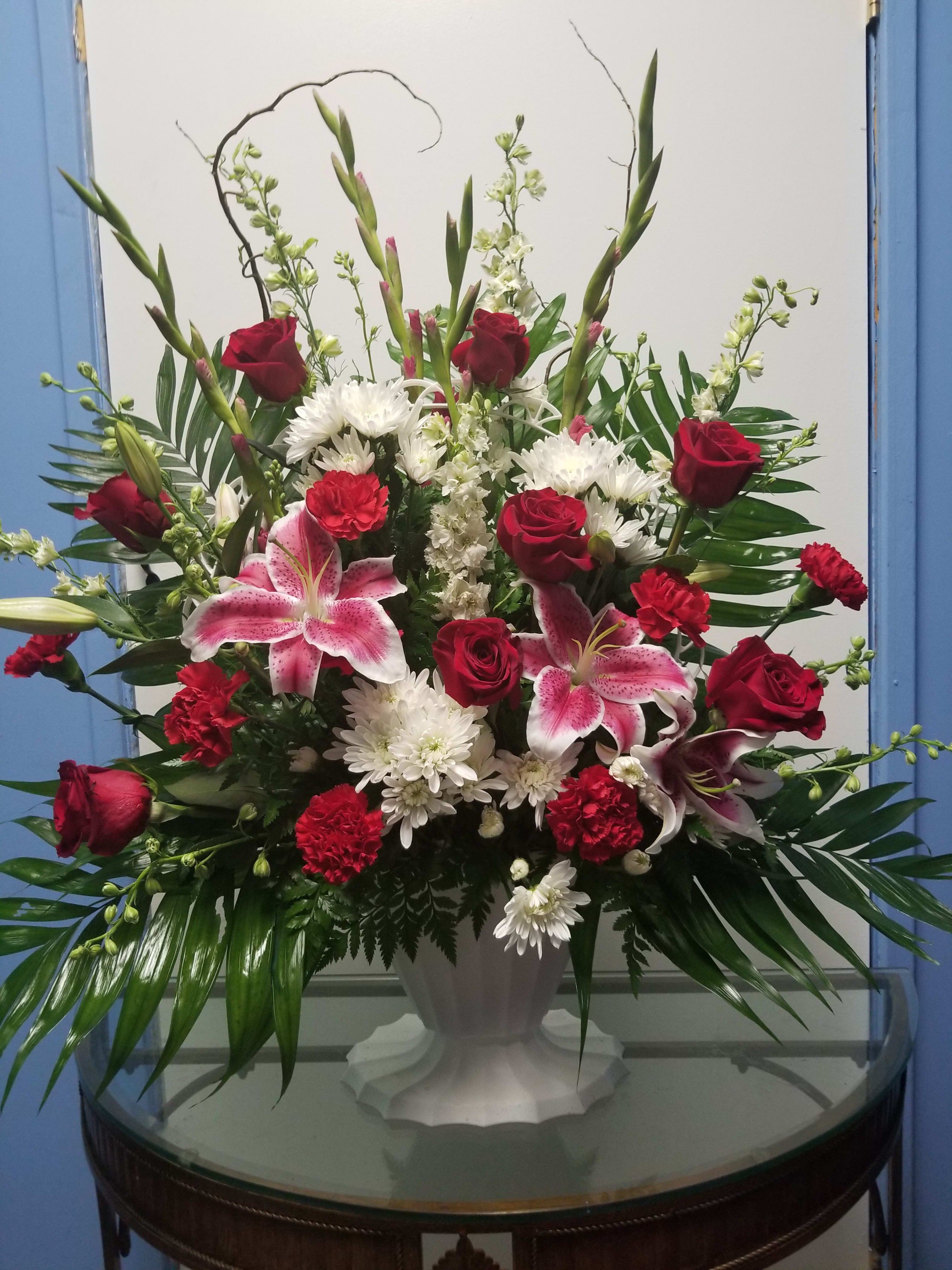 Large vase arrangement with red roses, pink lilies, and white chrysanthemums
