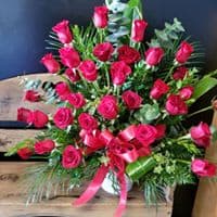Spirit of Roses Pedestal Arrangement - Two dozen red roses designed with red carnation, eucalyptus and seasonal greens. This is a stunning arrangement. 
