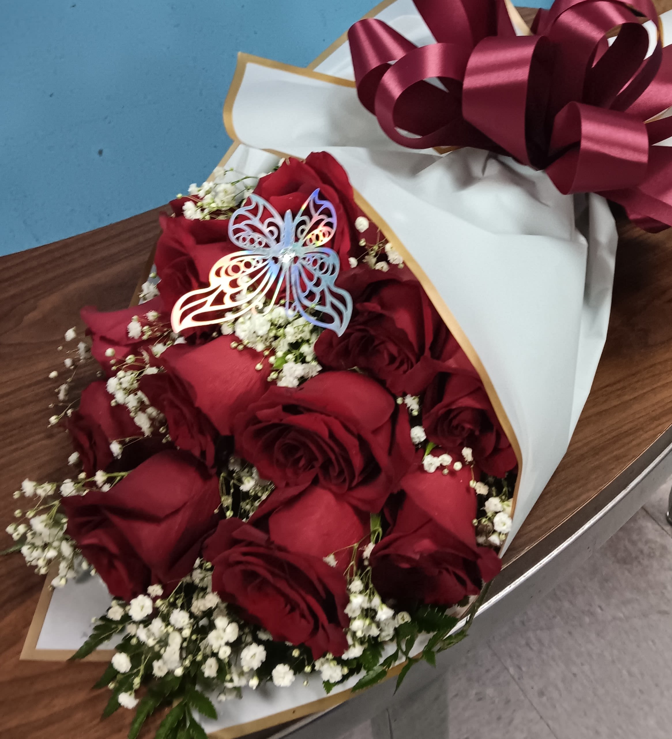 Bouquet of red roses with baby's breath in white wrapping