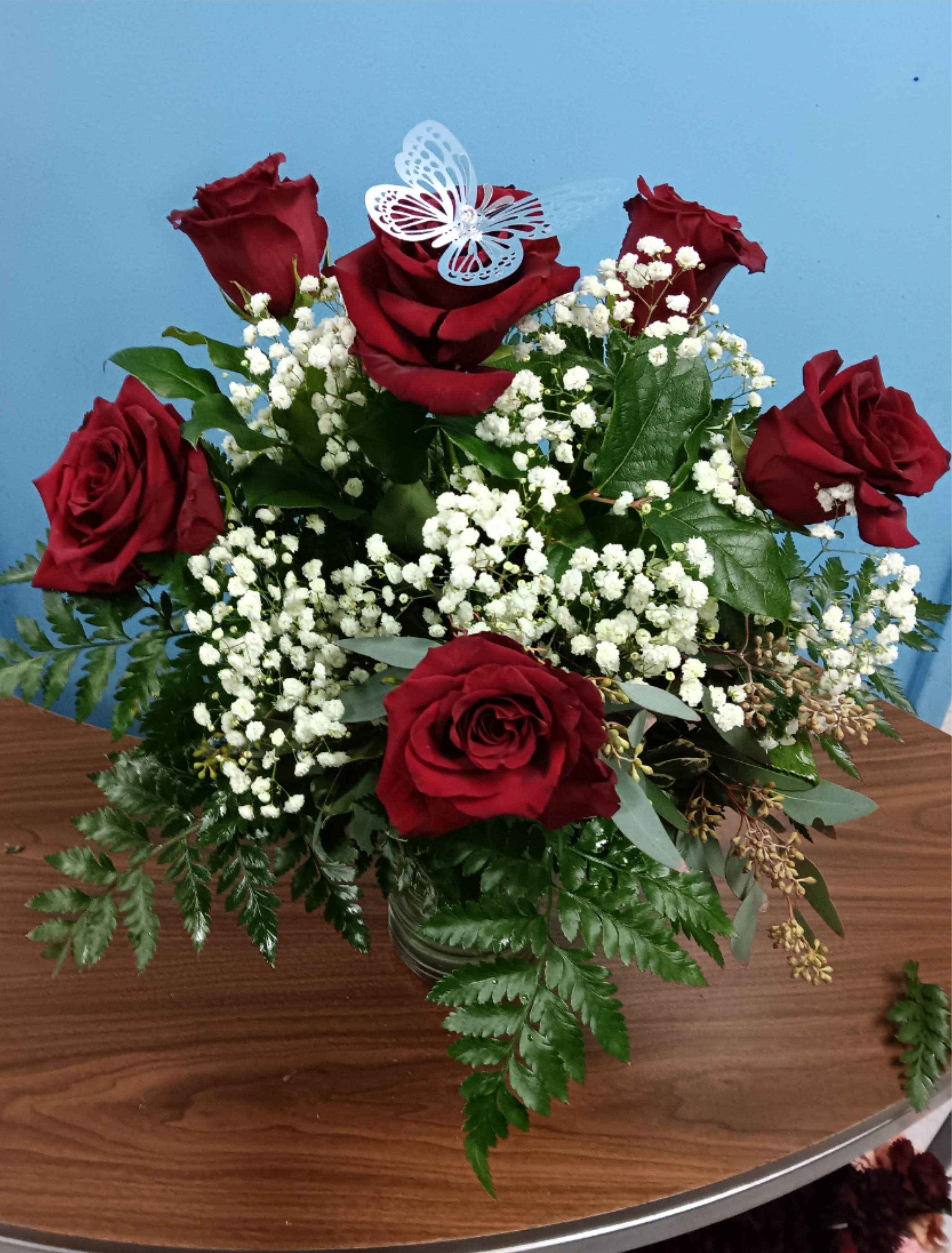 Red roses with white baby's breath in a glass vase