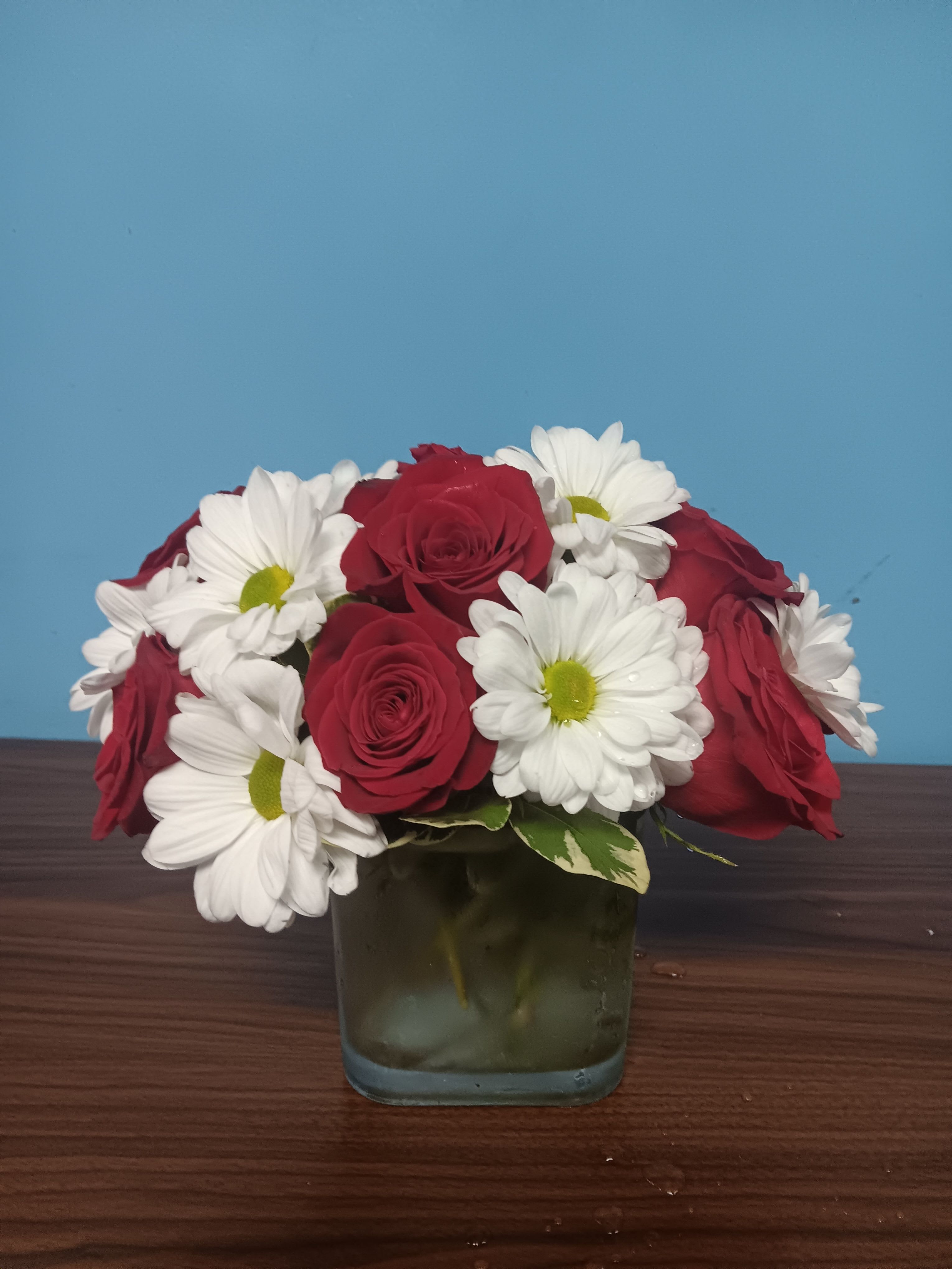 Daisy Me Rollin' by BloomNation - This arrangement contains spray daisies and spray roses. This is a great birthday gift. APPROXIMATE DIMENSIONS: 9"L X 9"W x 9"H