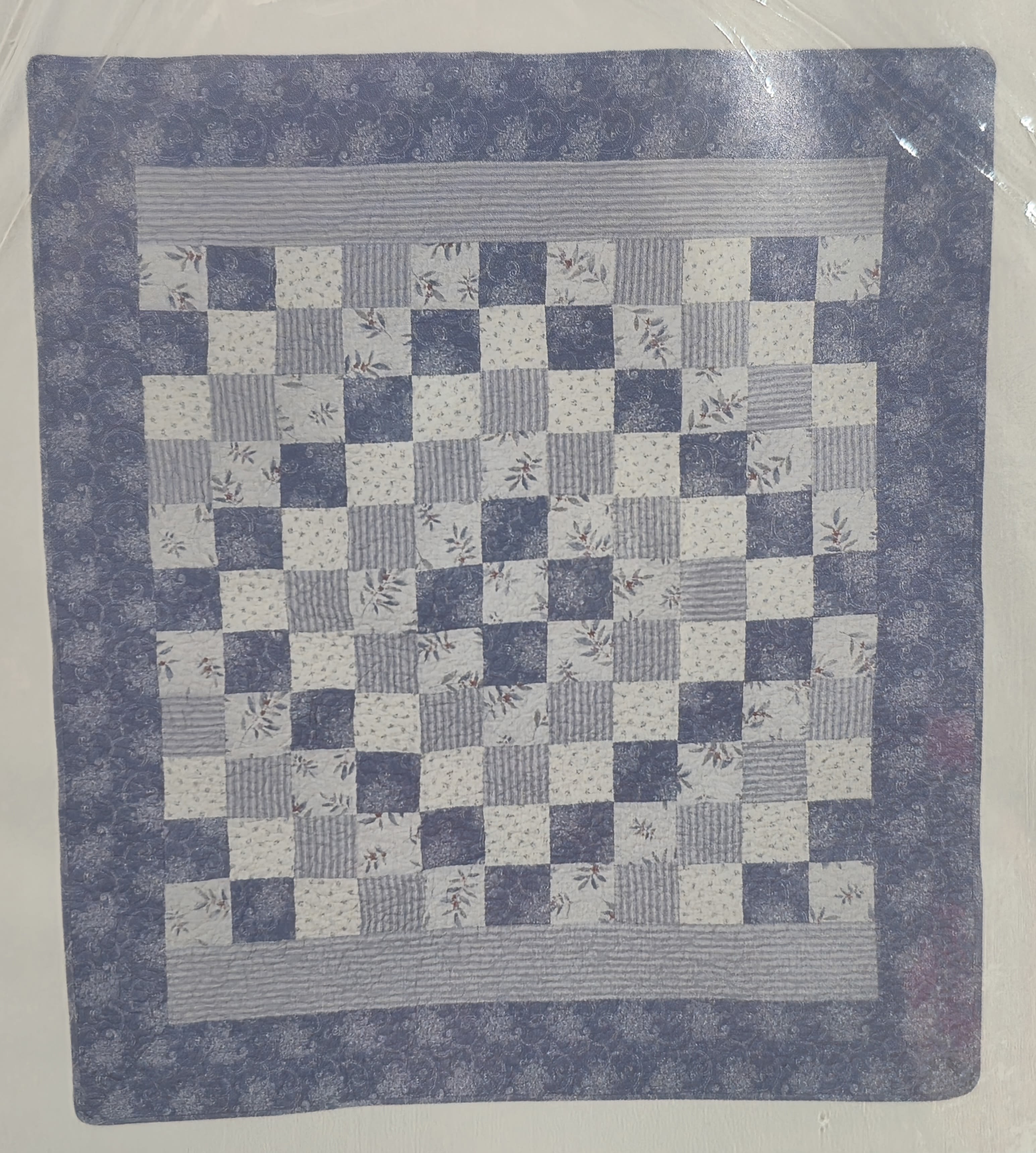 Blue and white patchwork quilt with a floral checkerboard pattern