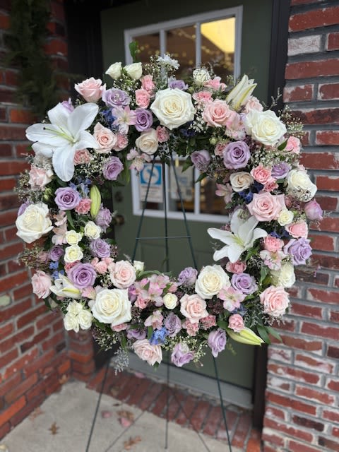Pastel floral wreath with roses and lilies on a stand