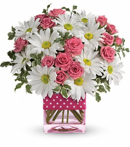 Pink roses and white daisies in a pink glass vase with polka dots