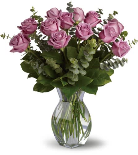 Lavender Wishes - Dozen Premium Lavender Roses - Lovely lavender roses are enchanting and exotic. They can even signify love at first sight and when this pretty bouquet is delivered it will surely be love. Gorgeous as the roses are by themselves when mixed with the dark forest green of eucalyptus the effect is intoxicating. Twelve delightful lavender roses eucalyptus and greens are delivered in a glass vase. It's a wish come true!Approximately 20" W x 21" H Orientation: All-Around As Shown : T68-1ADeluxe : T68-1BPremium : T68-1C