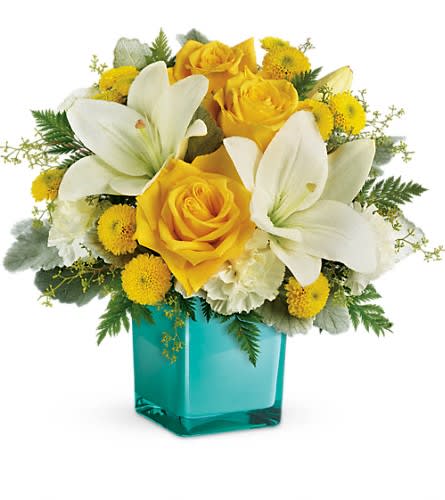 Yellow roses and white lilies in a turquoise glass vase