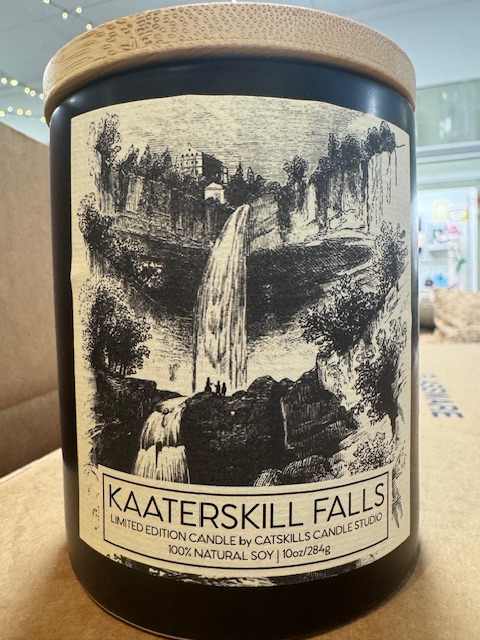 Black candle jar with a waterfall label and wooden lid