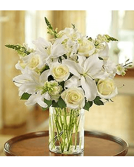 SIMPLY ELEGANCE WITH ROSES AND LILIES BOUQUET - Glorious roses lead the way in this luxurious white arrangement. Paired with lilies, snapdragons and greenery, they're hand-gathered in a stylish cylinder vase to evoke an evening stroll.