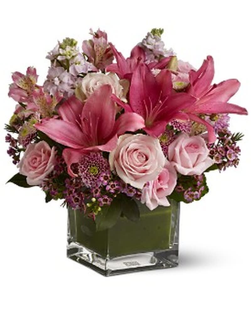 Hopeless Romantic - Show what a hopeless romantic you are. Have this gift of delicate pink and purple blossoms delivered right to their door, and your poetic spirit will shine through!  A mix of fresh pink and purple flowers such as roses, Asiatic lilies, stock and button spray chrysanthemums is delivered in a glass cube vase lined with a green leaf.