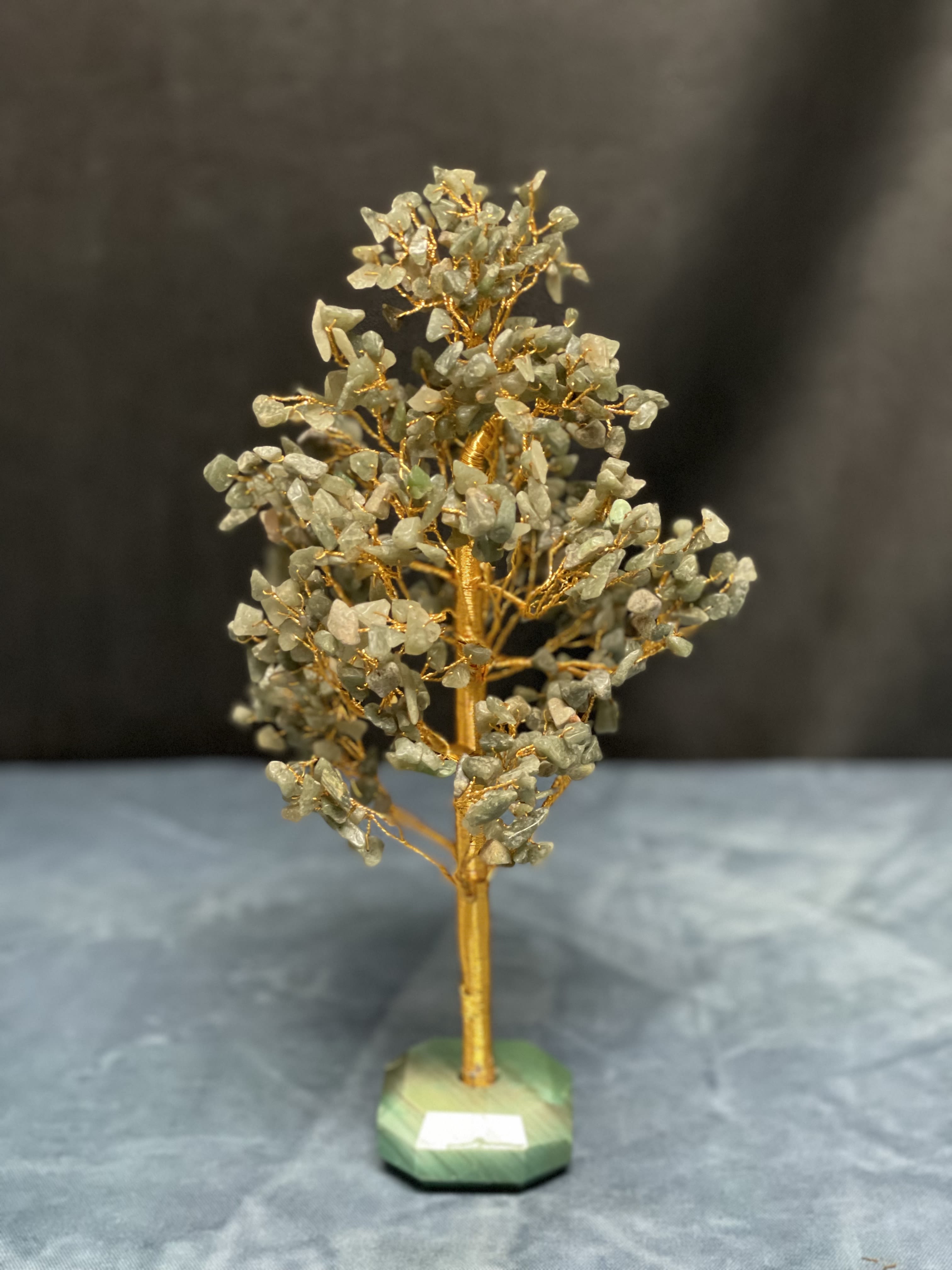 Gemstone tree sculpture with gold wire branches on a green stone base