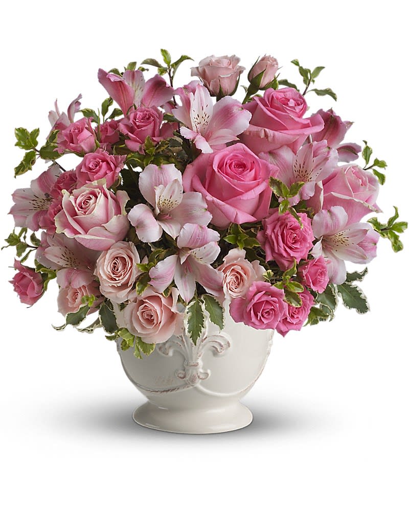 Pink roses and alstroemeria arranged in a white ceramic footed vase