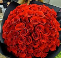 Large bouquet of red roses wrapped in dark paper