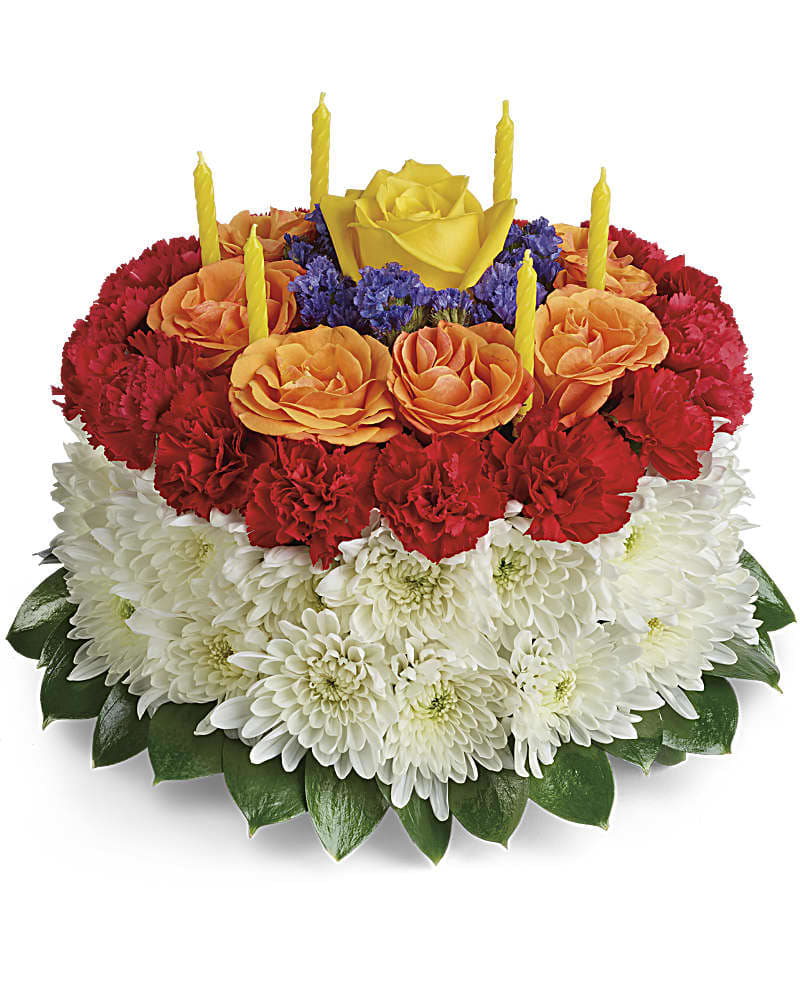 Tiered floral cake with red, orange, and white flowers and yellow candles