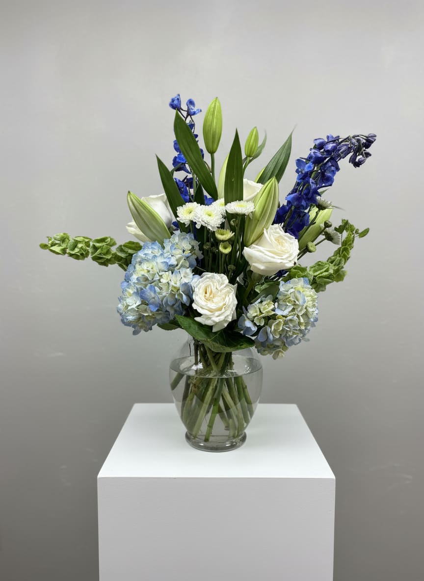 Blue and white floral arrangement in a clear glass vase