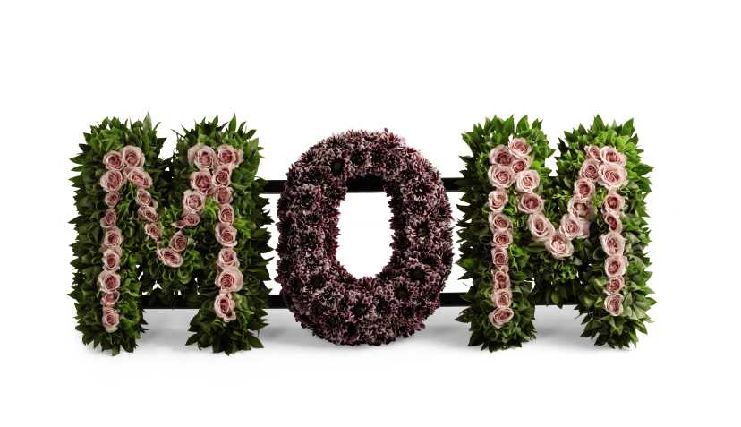 The FTD Remembering Mom Arrangement - The FTD Remembering Mom Arrangement honors the life and the love you have for your mother at her final farewell service. Light pink spray roses, plum daisy poms, Bells of Ireland, and myrtle stems are artfully arranged to spell the word, âMom,â creating a wonderful memorial for the woman who continues to shape your life's journey.