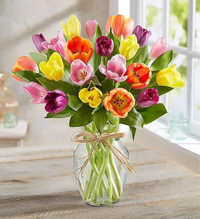 Bouquet of multicolored tulips in a clear glass vase