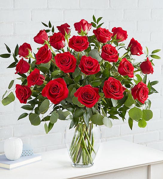 Red roses arranged in a clear glass vase