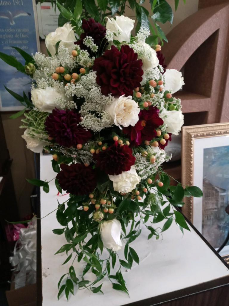 Tall bouquet of white and burgundy flowers with trailing greenery