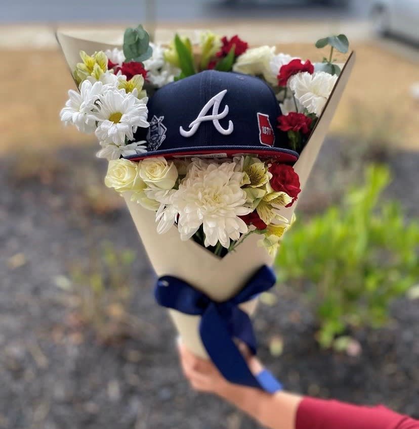 Bouquet with white and red flowers around a navy baseball cap