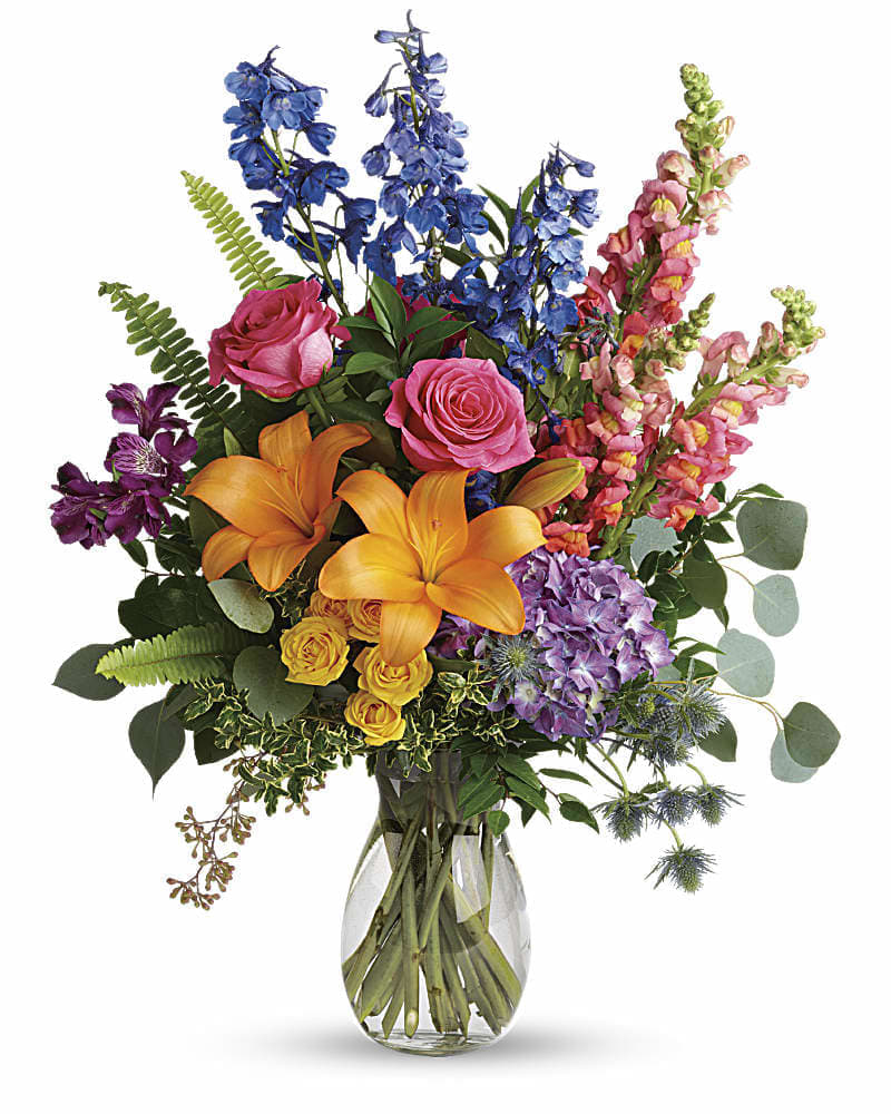 Colorful bouquet with lilies, roses, snapdragons, and hydrangea in a glass vase