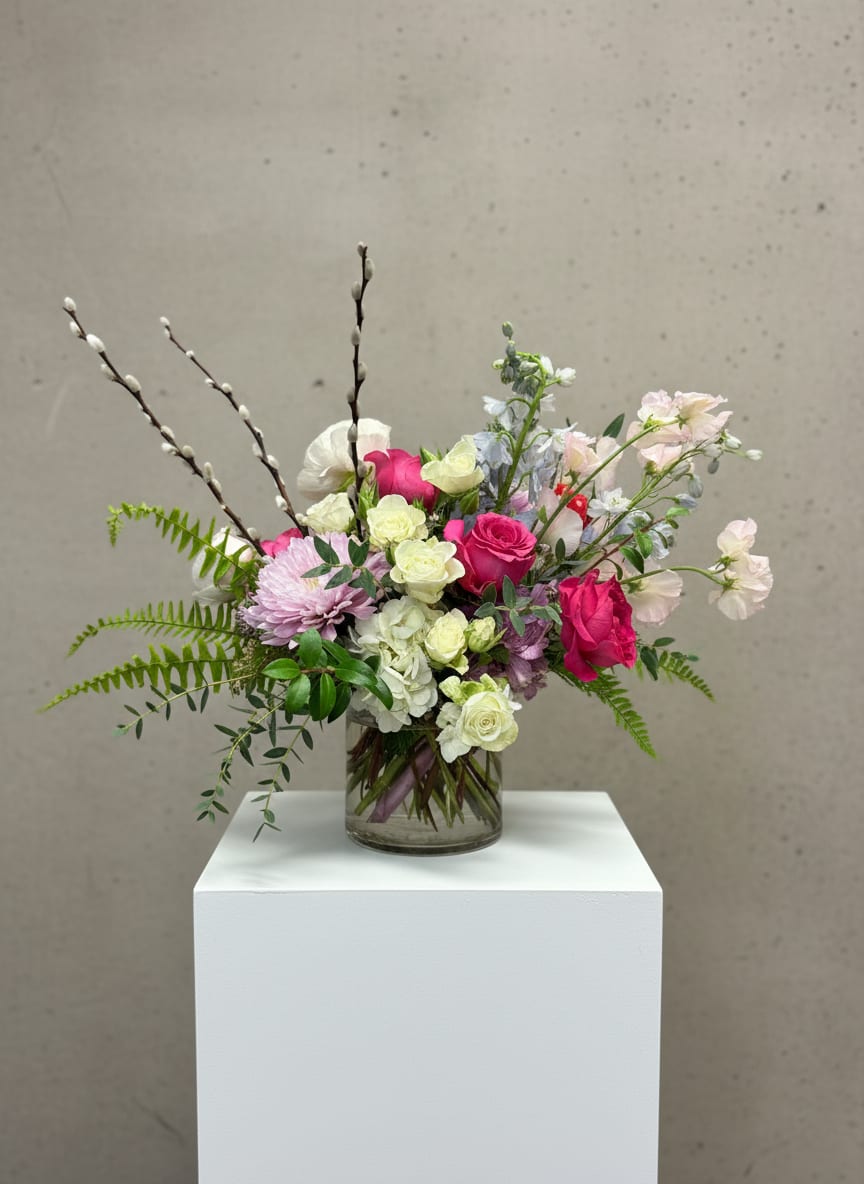 Mixed pink and white flowers arranged in a clear glass vase