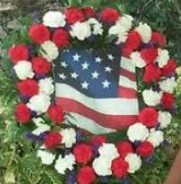 Red, white, and blue floral wreath around an American flag