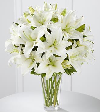White lilies arranged in a clear glass vase
