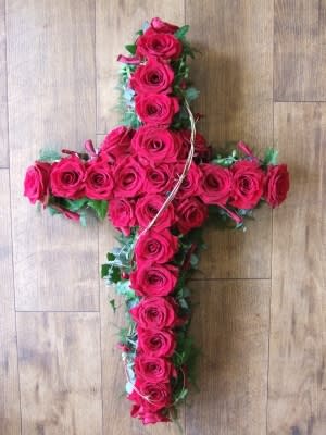 Cross-shaped arrangement of hot pink roses with greenery