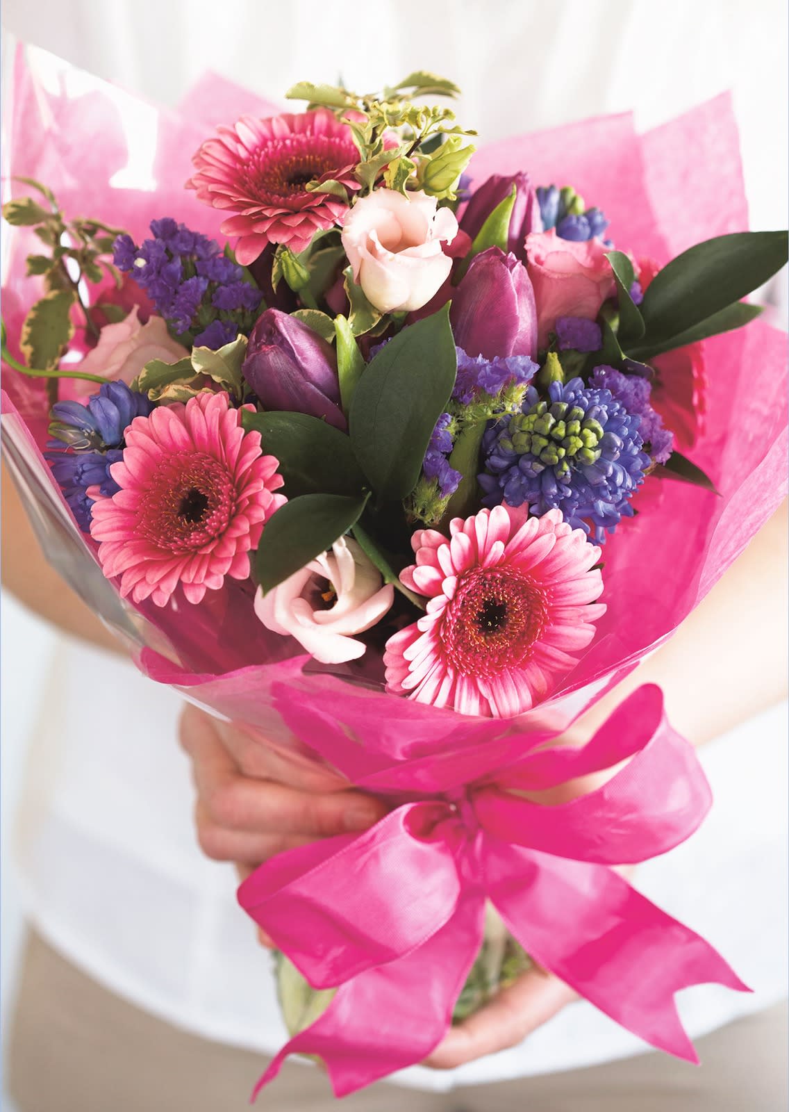 Pink and purple mixed bouquet wrapped in bright pink paper