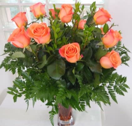 Peach roses arranged in a clear glass vase