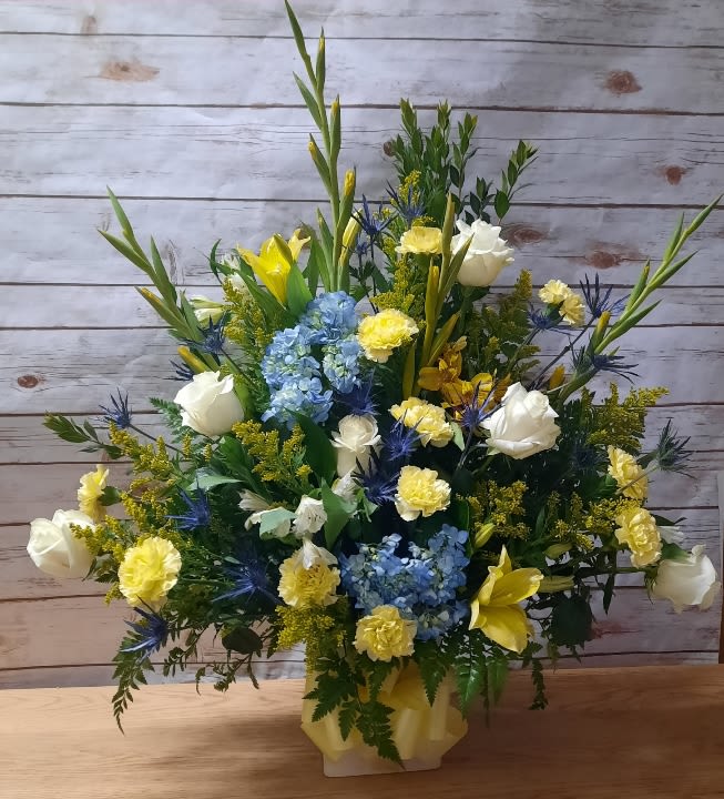 Mixed bouquet with blue hydrangeas, white roses, and yellow lilies in a vase