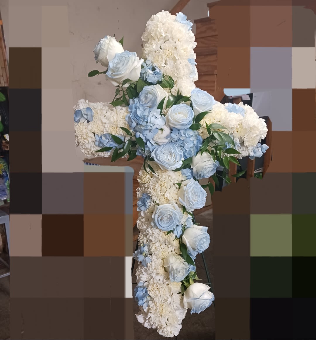 White and pale blue floral cross arrangement on a stand