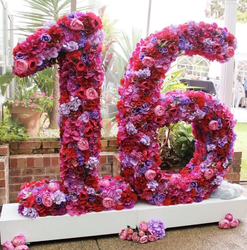 Large floral number 16 covered in pink, red, and purple blooms