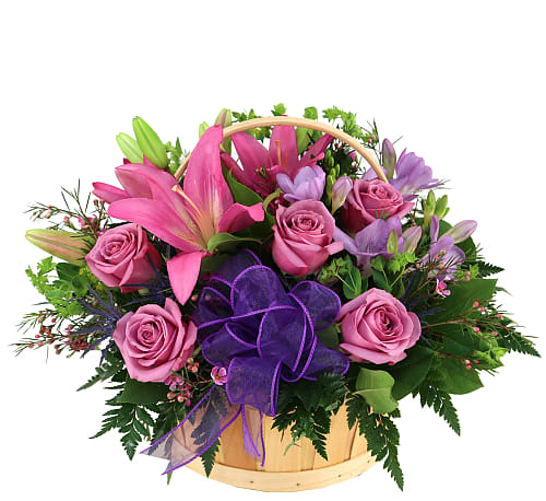 Pretty Flower Basket - A lovely handled basket floral design of lavender roses, freesias, pink lilies, waxflower, lush greenery and purple organza ribbon.
