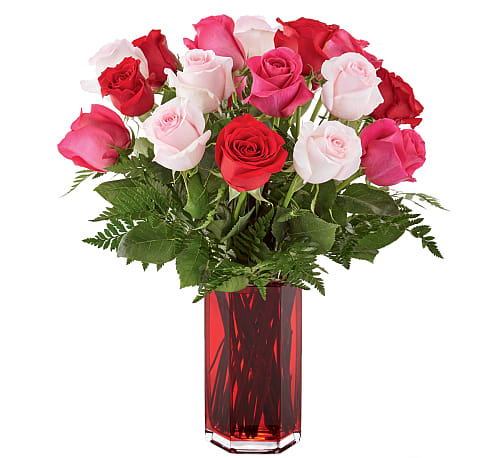Bouquet of red, pink, and white roses in a red glass vase