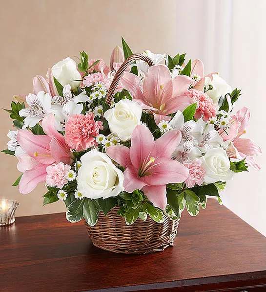 Peac &amp; Blessings   Pink &amp; White basket  - Representing care, compassion and love - pink blooms can offer solace in times of sorrow. Artistically designed inside a keepsake willow basket, our arrangement in soothing pink hues is a touching way to offer your sincerest blessings.  white roses, alstroemeria and monte casino and pink Asiatic lilies, carnations and mini carnations; accented with fresh greenery