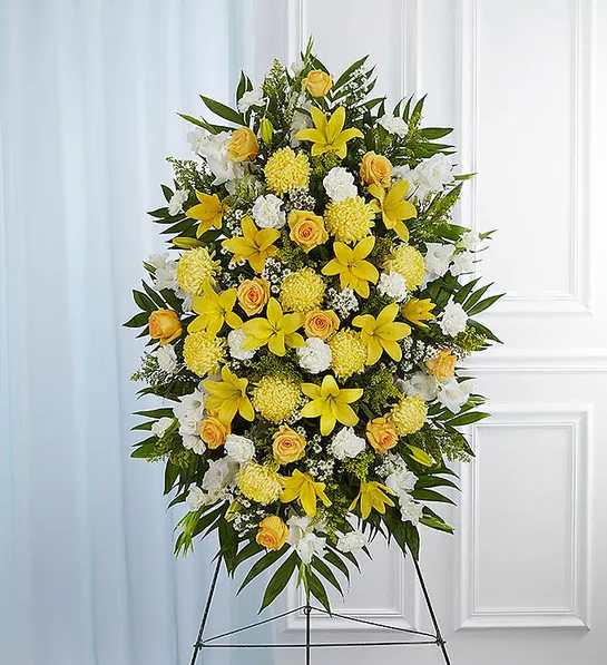 Yellow &amp; White Sympathy Standing Spray - A ray of hope can mean everything after the loss of a loved one. Both bright and abundant, our impressive standing spray arrangement, meticulously handcrafted by expert local florists with sunny yellow and rich white blooms, offers a grand gesture of peace, comfort and light during a difficult time.Standing spray arrangement with yellow roses and daisy poms; white yellow Asiatic lilies , gladiola, yellow football mums , carnations and monte casino; accented with soft, lush greenery