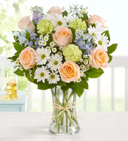 Summer Dunes - Our beach-inspired bouquet captures the blissful beauty of a seaside retreat. Bunches of blooms in cool, soothing shades are arranged in a glass vase tied with raffia for an extra touch of coastal style. It’s a gift that celebrates the carefree spirit of summer, while surprising the people you care about most.