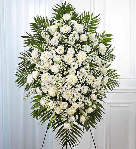 White Funeral Standing Spray - White flowers have a peacefulness and purity to them, bringing hope and light during a time of loss. Our impressive standing spray arrangement is meticulously handcrafted by expert local florists with an abundance of pristine white blooms for a lush, full presentation. Let it be a grand and memorable tribute to one who was loved so dearly. 