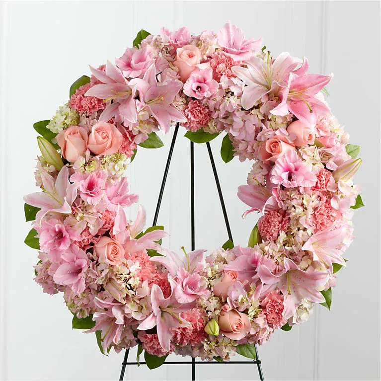 Pink floral wreath on a black stand