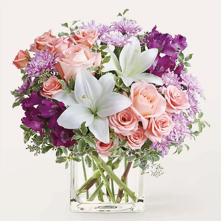 Pink roses and white lilies in a clear glass vase