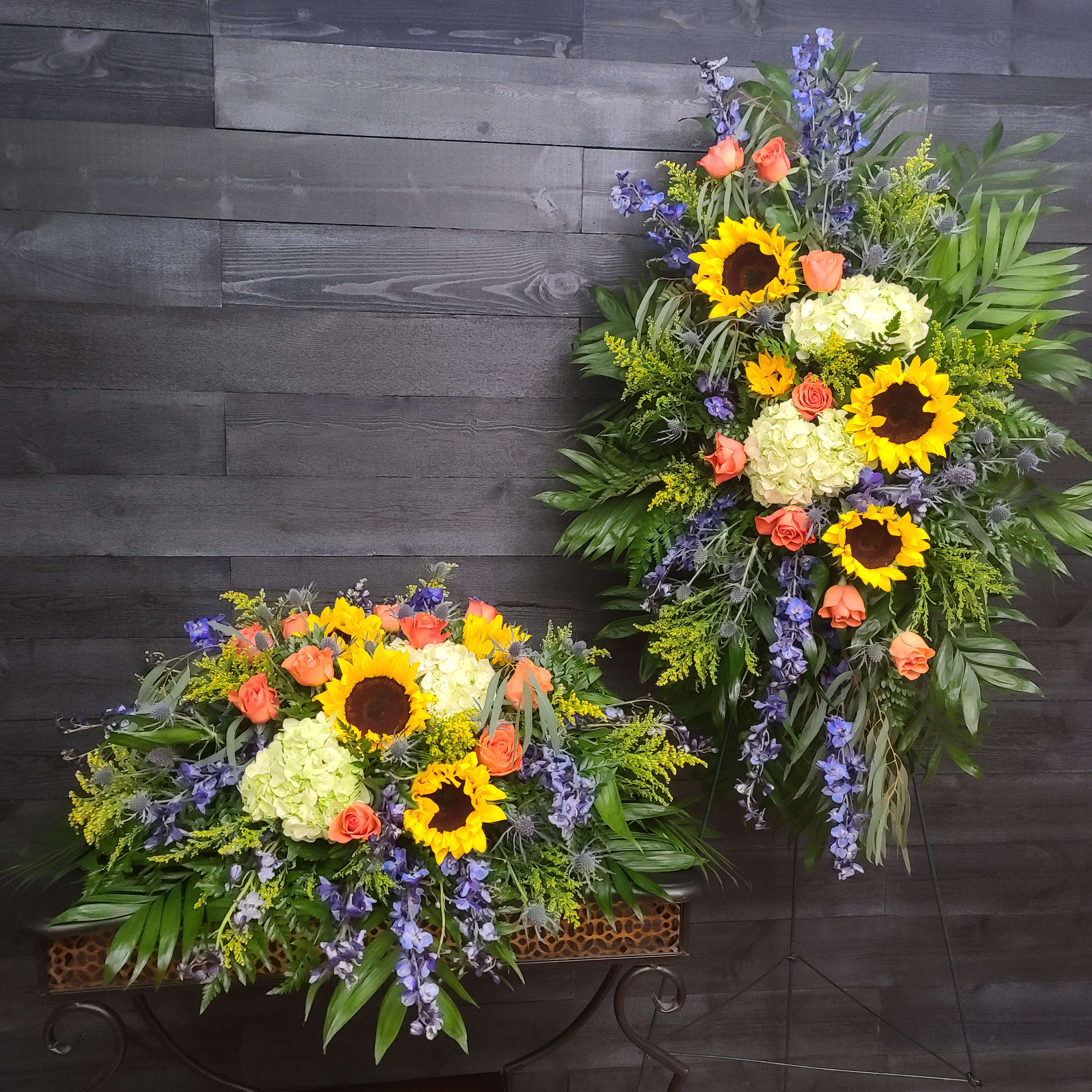 Two large floral sprays with sunflowers, roses, and hydrangeas on stands