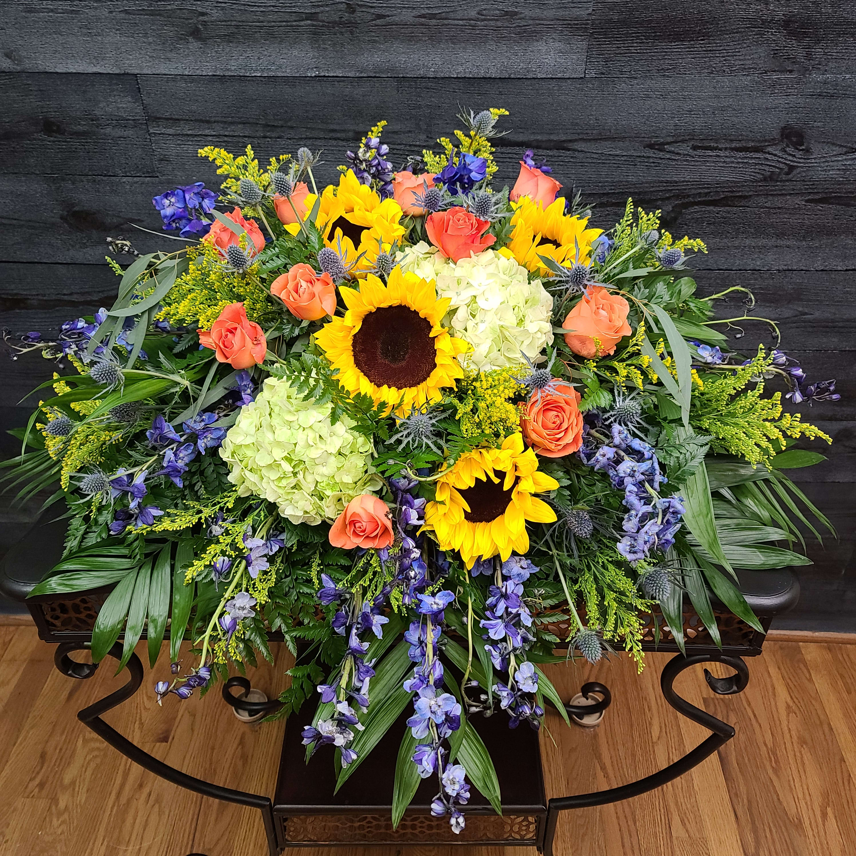 Large mixed bouquet with sunflowers, orange roses, and pale hydrangeas