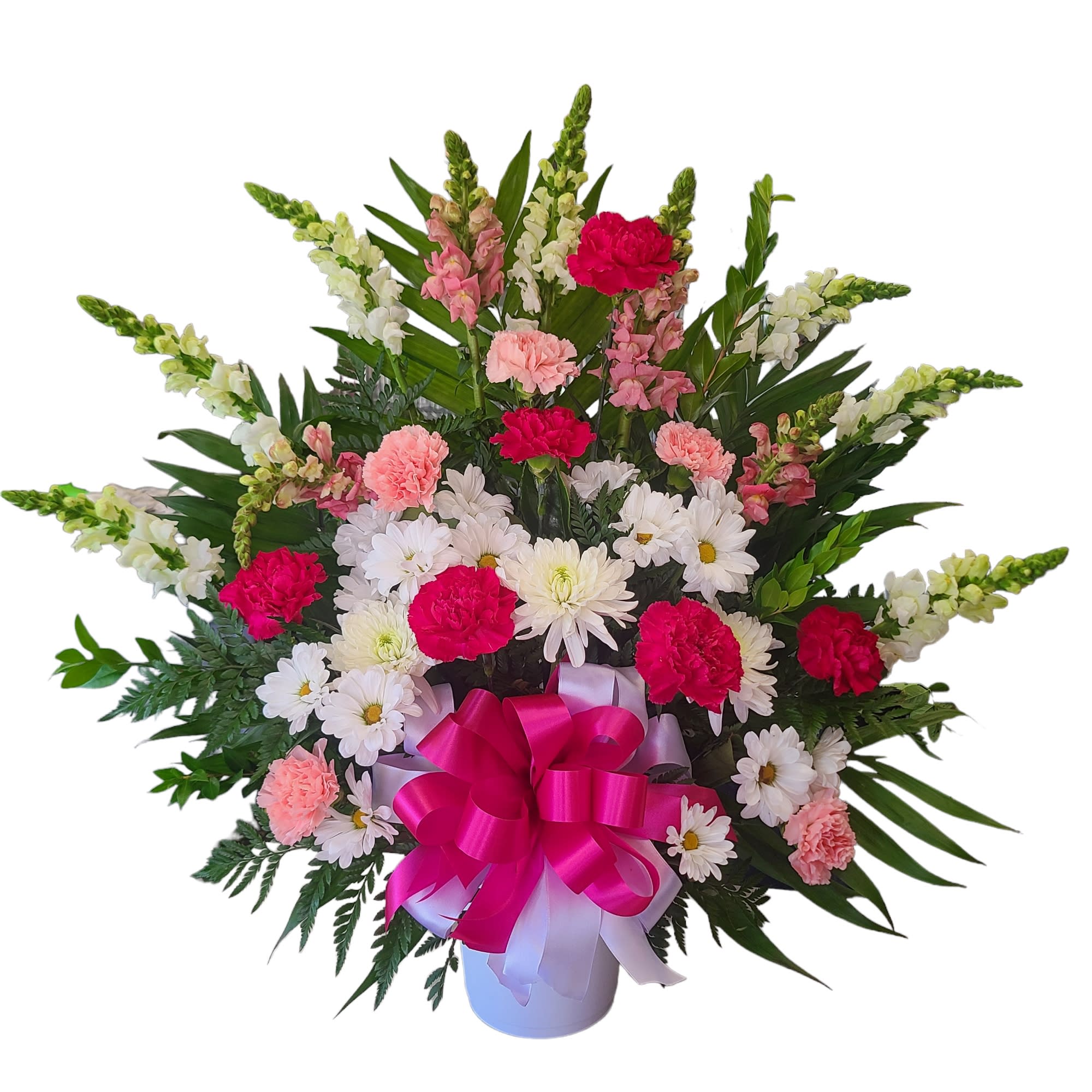 Pink and white flowers arranged in a white vase with a magenta bow