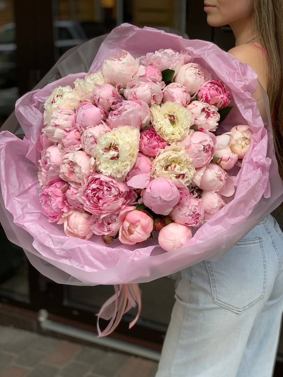 Large bouquet of pink peonies wrapped in pink paper