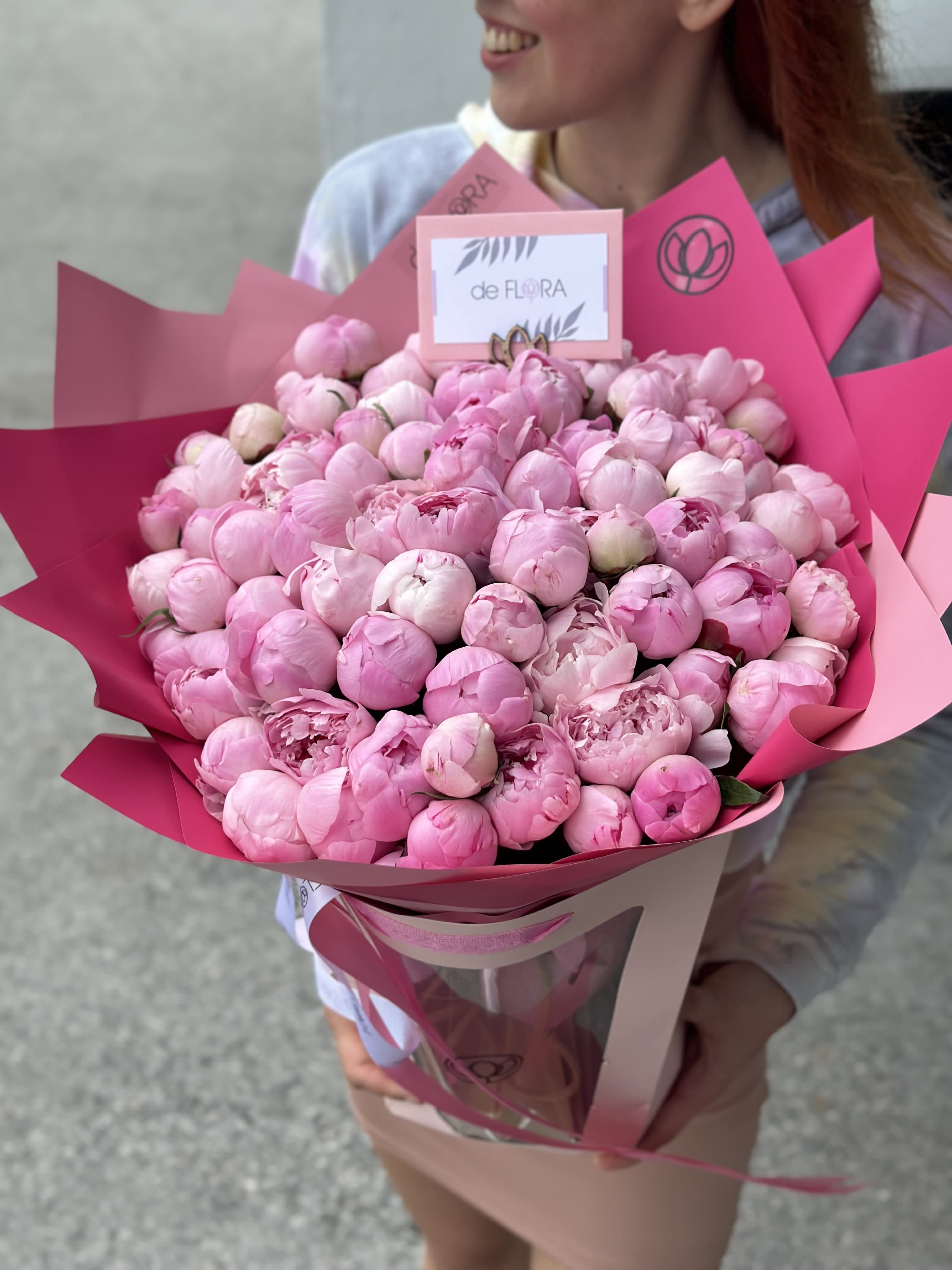 Large bouquet of pink peonies wrapped in bright pink paper