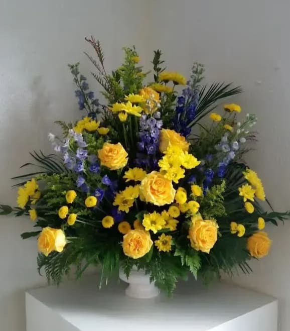 Yellow roses and purple flowers in a white vase